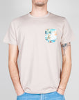 Uomo che indossa un T-shirt taschino V2 Art. TUCL, colore beige con taschino a motivi floreali.
