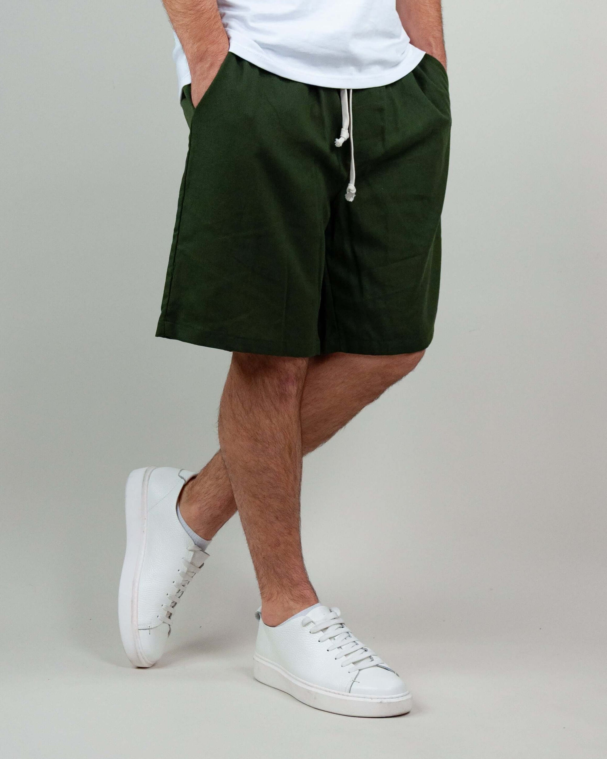 Bermuda Misto Lino Corfu in verde scuro, abbinati a scarpe bianche, ideale per il comfort estivo.