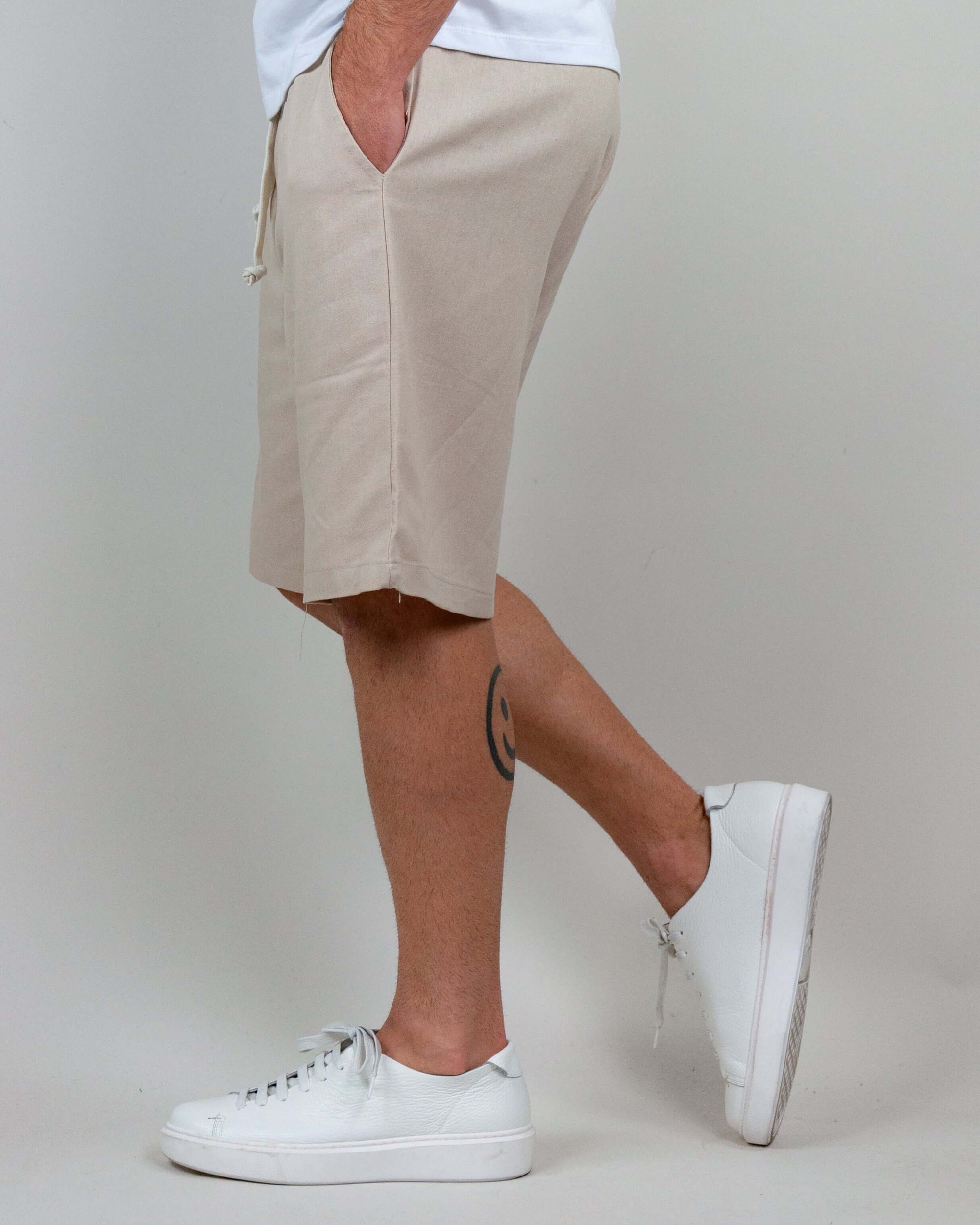 Bermuda Misto Lino Corfu in beige, featuring side pockets and paired with white sneakers, ideal for summer wear.
