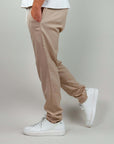 Man wearing beige Pantalaccio Paros, made of linen and rayon, paired with white sneakers.