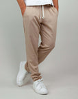 Pantaloni Pantalaccio Paros in misto lino e rayon, colore beige, abbinati a sneakers bianche per un look casual.