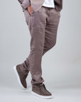 Pantalone in lino color sabbia per uomo, elegante e leggero, indossato con sneakers casual.