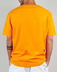 Back view of a man wearing an orange T-shirt, showcasing its semi-over fit and comfortable cotton fabric.