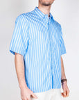 Camicia riga manica corta Officina 36 Uomo Art. 0341700518 indossata da modello, tessuto in cotone azzurro a righe.
