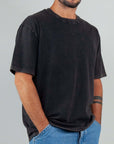 Black semi-over T-shirt with micro logo, 100% cotton, modeled by man in size M, casual style.