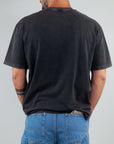 Back view of a man wearing a black T-shirt with Amish art micro logo and denim shorts, showcasing the semi-over fit.