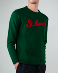 Maglione Superculture Girocollo St. Moritz in green with red lettering, perfect for stylish winter wear.
