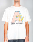 T-shirt artigianale Amish design televisivo in colore panna, con logo A-TV e stile unico, indossata da un uomo.