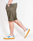 Uomo che indossa Bermuda cotone Officina 36 Leni in colore verde scuro, taglia 48, con scarpe bianche e blu.