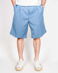 Bermuda Fresco in blue worn by a model showcasing a stylish summer outfit.