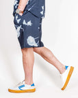 Bermuda Viscosa worn by a model, showcasing a casual outfit and stylish sneakers.