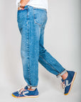 Model wearing jeans Jeremiah Uomo Powder Denim Amish Art, showcasing denim fabric and sporty shoes.