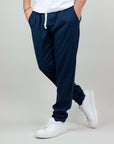 Uomo in pantaloni Pantalaccio Paros blu con tasche e sneakers bianche, in misto lino e rayon, per comfort e stile.