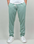 Pantaloni verde chiaro con coulisse, comodi e alla moda, abbinati a sneakers bianche.