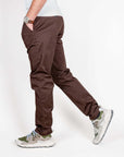 Uomo in pantalone slim fit cotone marrone Officina 36, indossando sneakers e orologio, modello elegante.