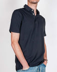Uomo che indossa una polo manica corta Piquet tinto in un colore scuro, modello casual e comodo.