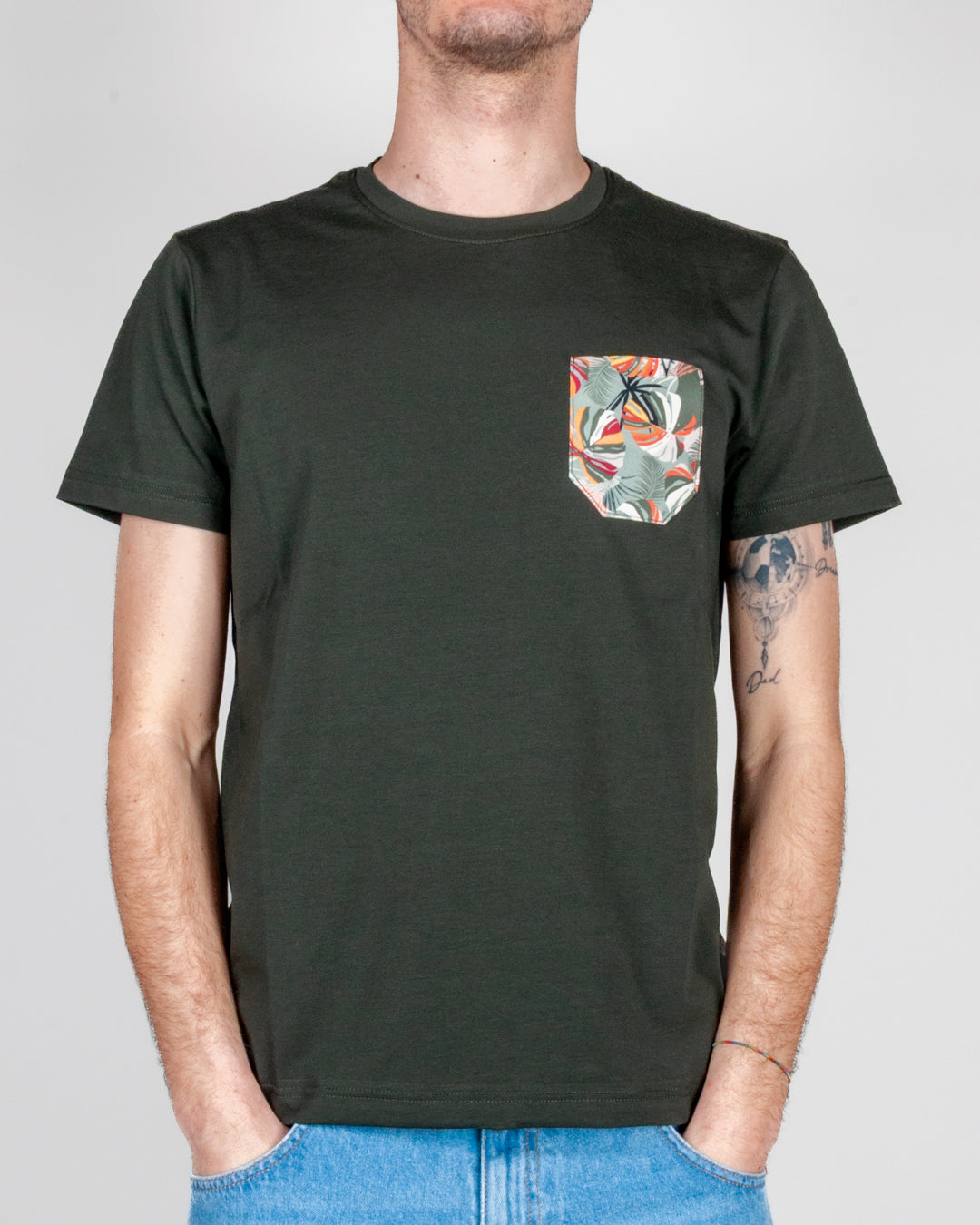 T-shirt taschino V2 Art. TUCL, con taschino colorato su sfondo verde scuro.