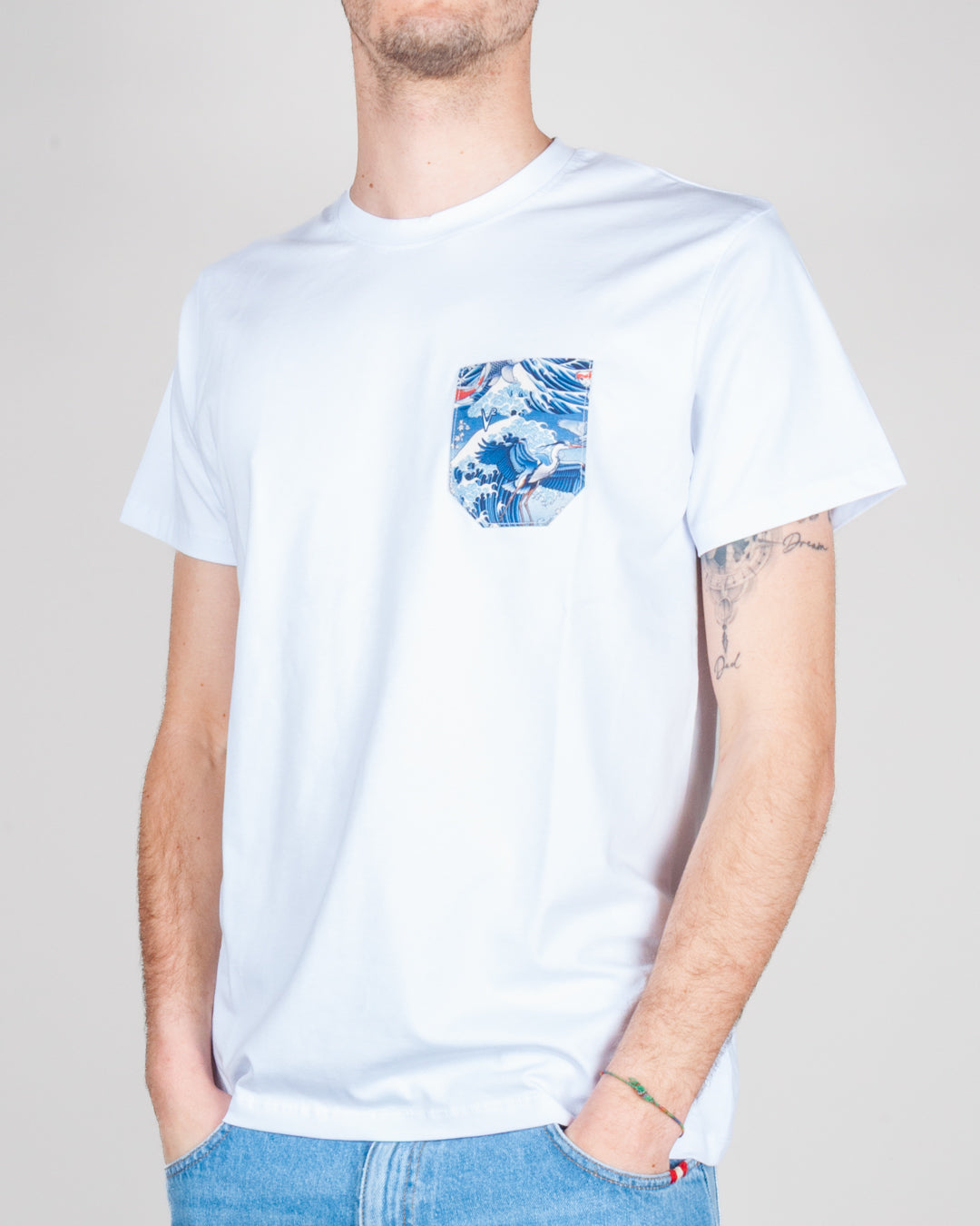 Modello T-shirt taschino V2 Art. TUCL con taschino decorato in blu e bianco, indossata da un uomo.