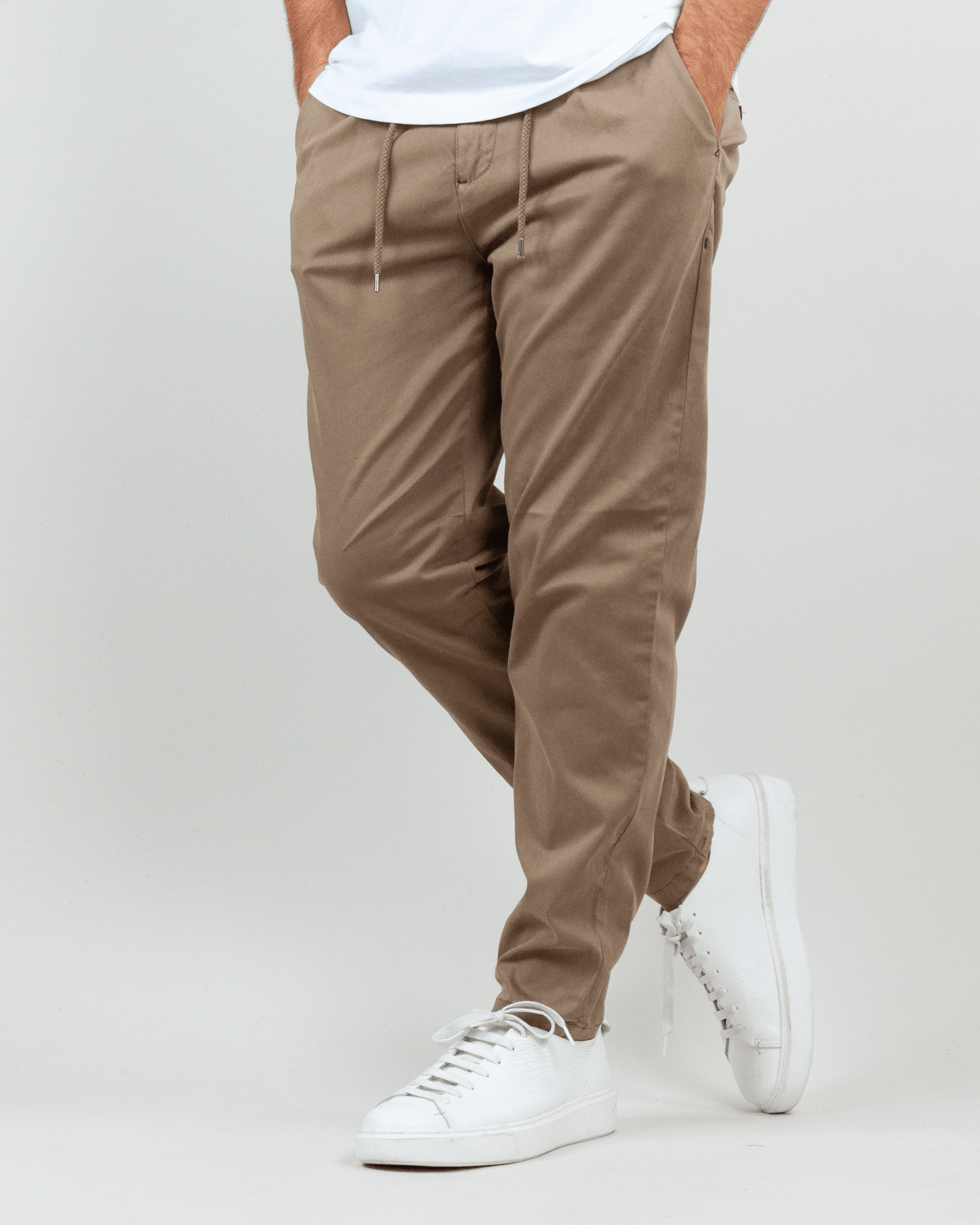 Pantalaccio Berna Uomo Art. BRN M 252112, stylish beige pants modeled with white sneakers.