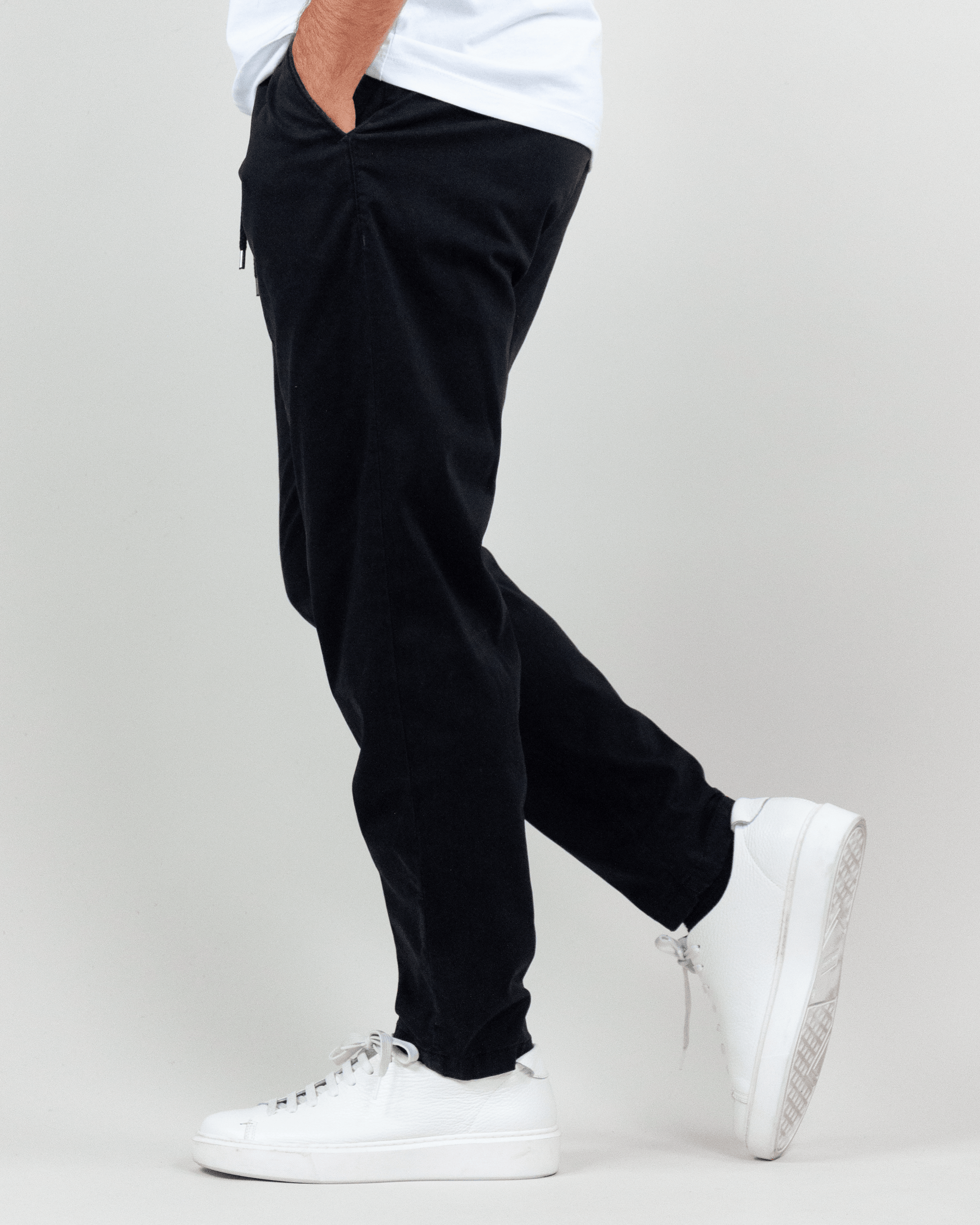 Pantalaccio Berna Uomo Art. BRN M 252112 in black worn with white sneakers, showcasing a stylish side view.