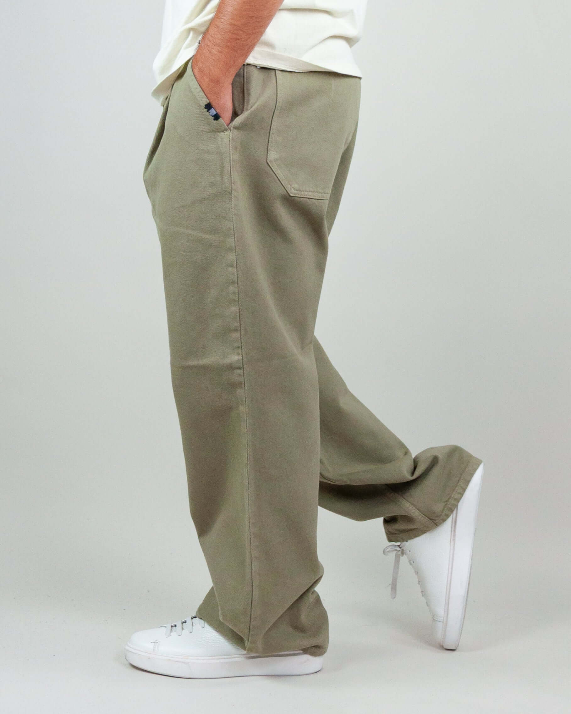 Model wearing Pantalone Twill Amish Nogend Art in khaki cotton fabric, showcasing side view and relaxed fit.