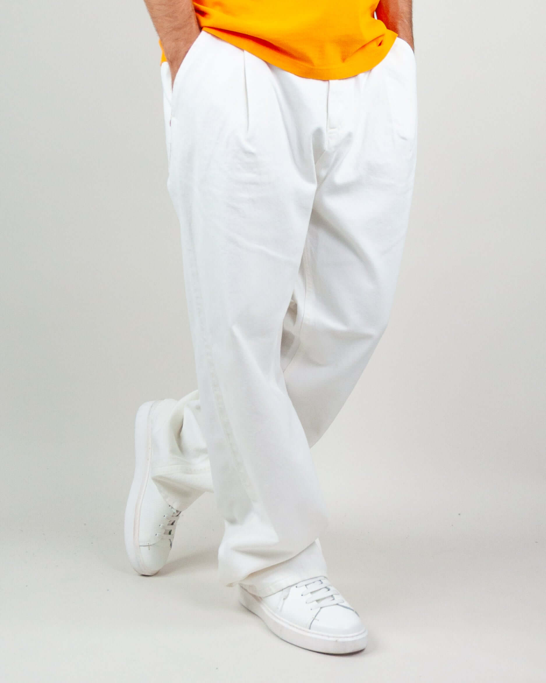 Pantalone Twill Amish Nogend Art in white, styled with a casual orange t-shirt and white sneakers.