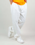 Pantalone Twill Amish Nogend Art in white, styled with a casual orange t-shirt and white sneakers.