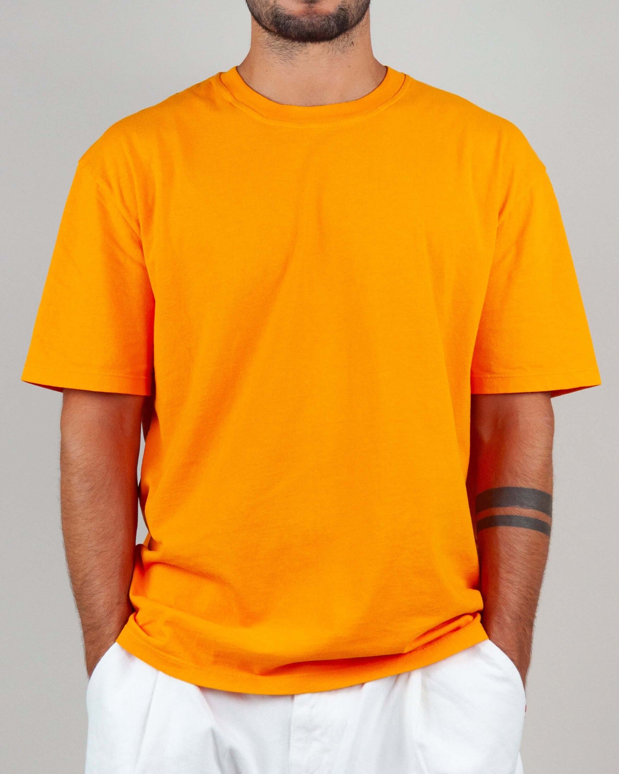 Model wearing an orange t-shirt, semi-over fit, made of 100% cotton, perfect for casual outfits.