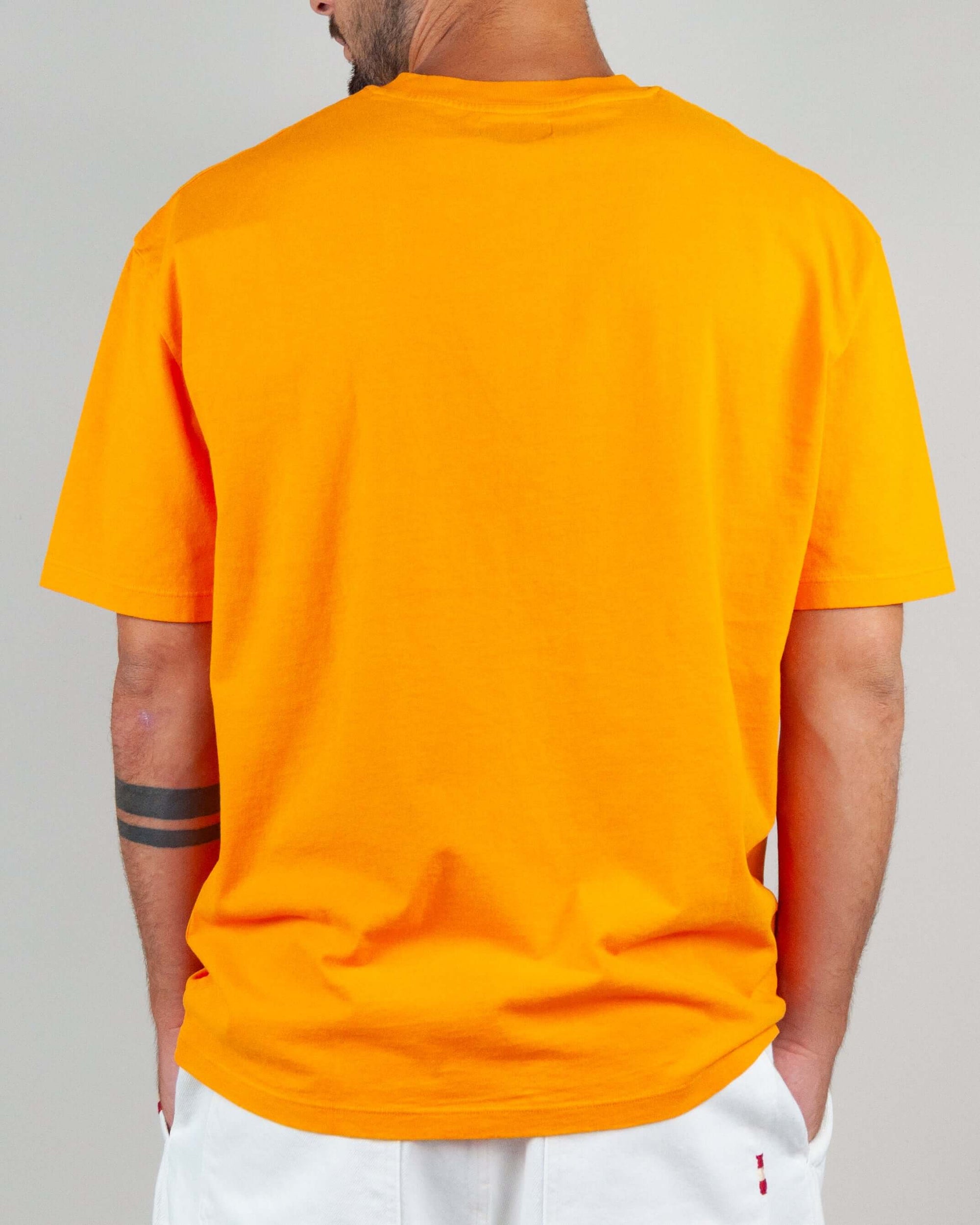 Back view of a man wearing an orange T-shirt, showcasing its semi-over fit and comfortable cotton fabric.