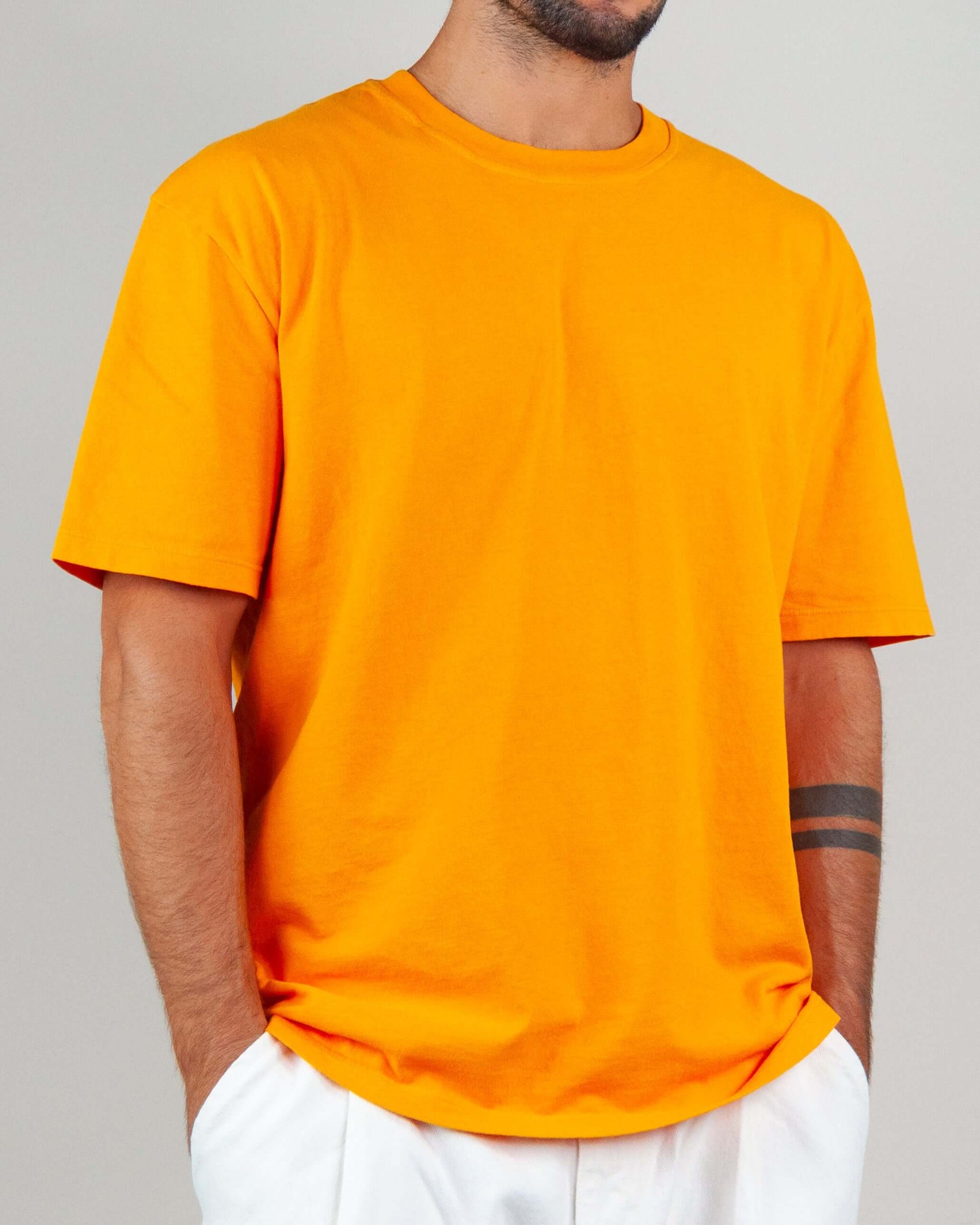 Men's orange T-shirt with micro logo, made of 100% cotton, semi-overfit, model wearing size M.