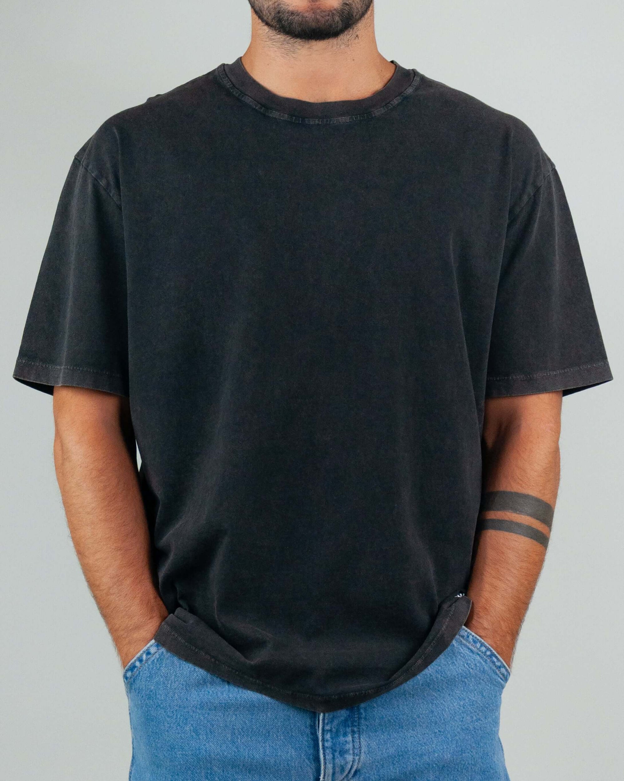 Black T-shirt with micro logo, semi over fit, worn by a model, made of 100% cotton.