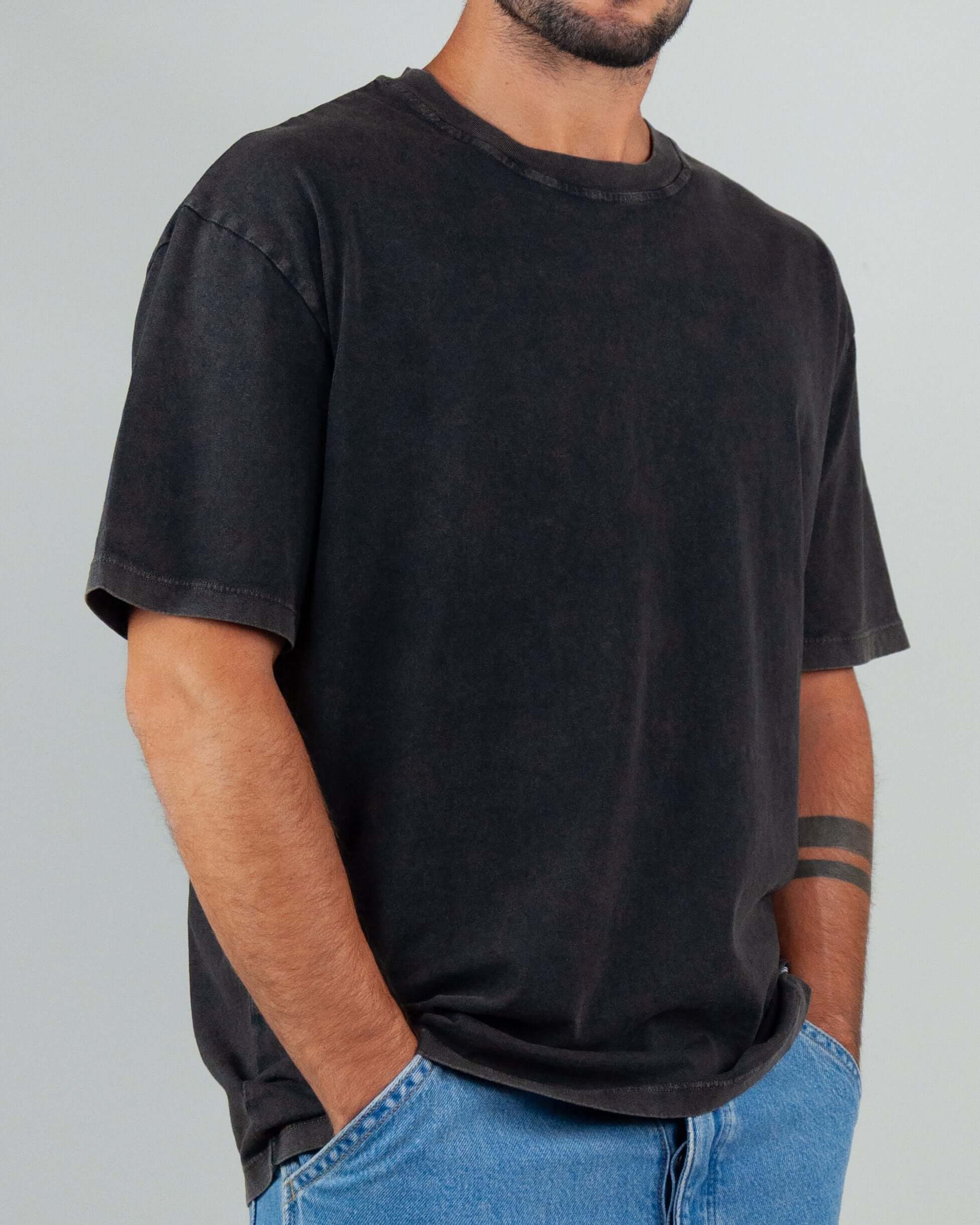 Black semi-over T-shirt with micro logo, 100% cotton, modeled by man in size M, casual style.