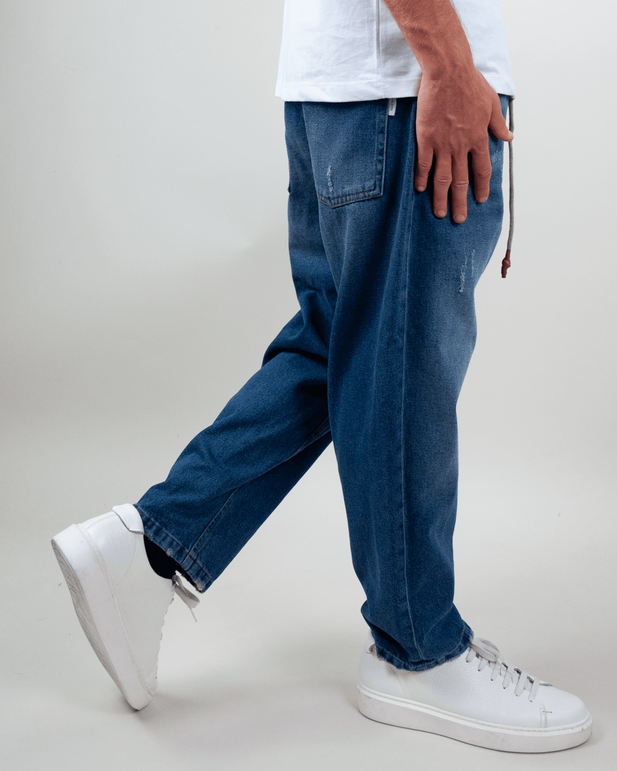 Man wearing Jeans Coulisse Uomo, showing a stylish side view with white sneakers.