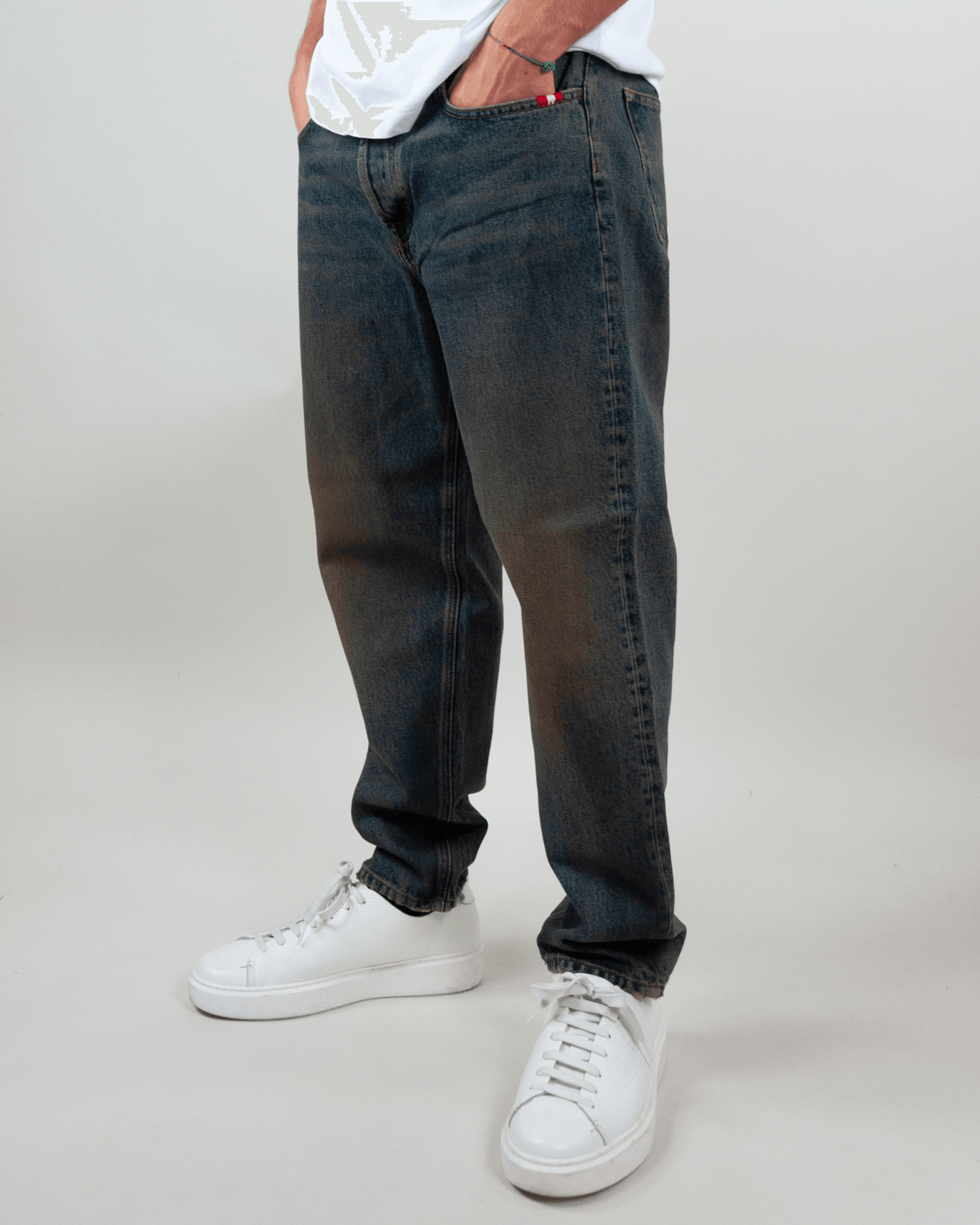 Amish Jeremiah Green dirty denim jeans displayed on a model wearing white sneakers, showcasing stylish casual wear.