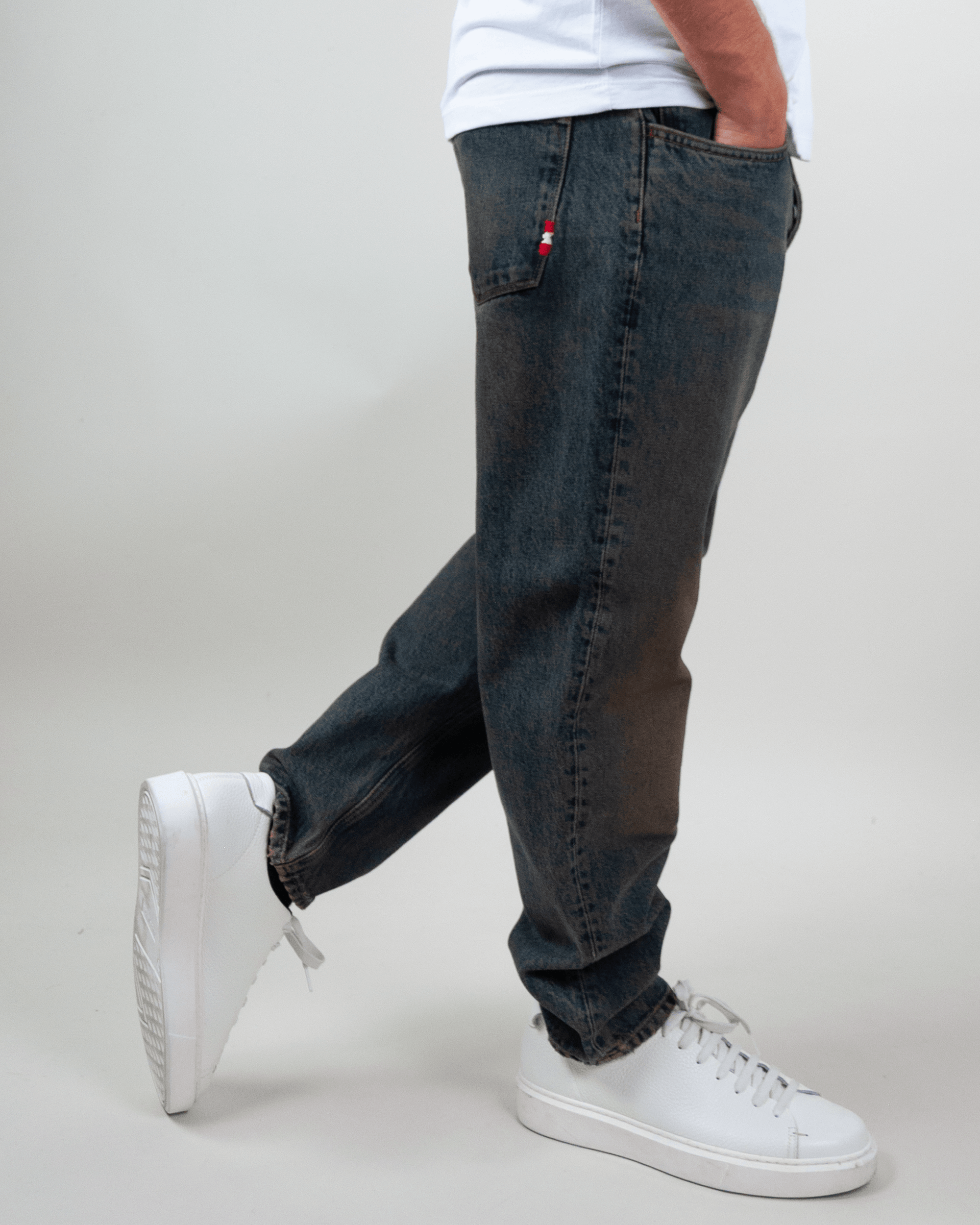 Amish Jeremiah Green dirty denim jeans worn by a person with white shoes, showcasing a casual style.