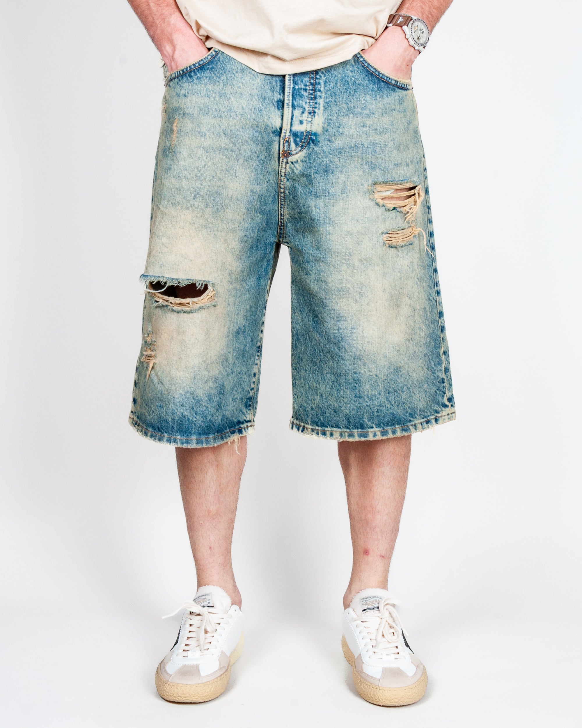 Bermuda Ampio in Denim I'm Brian worn by a model, showcasing ripped design and medium wash, size 32.