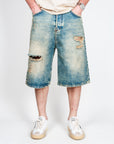 Bermuda Ampio in Denim I'm Brian worn by a model, showcasing ripped design and medium wash, size 32.
