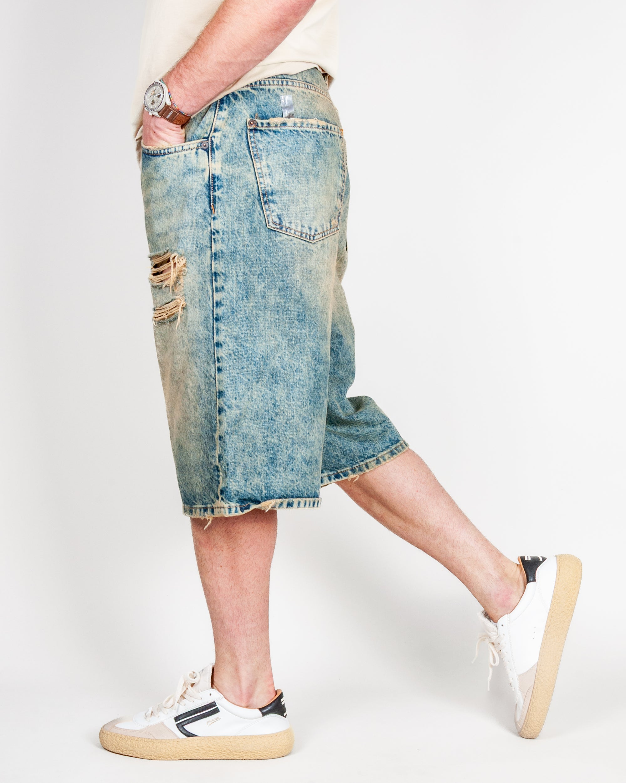Bermuda Ampio in Denim I'm Brian worn by a model, size 32, showcasing the stylish ripped details and denim fabric.
