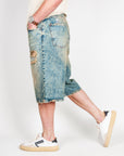 Bermuda Ampio in Denim I'm Brian worn by a model, size 32, showcasing the stylish ripped details and denim fabric.