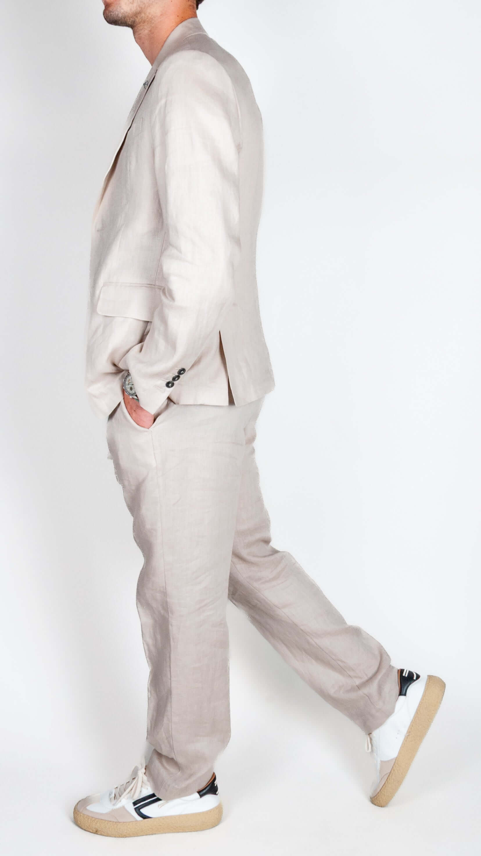 Abito lino 100% Lino Officina36 beige indossato da uomo con sneakers bianche, vista laterale.