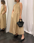 Abito donna cotone eleganza in beige con scollatura semplice e borsa nera, perfetto per ogni occasione.