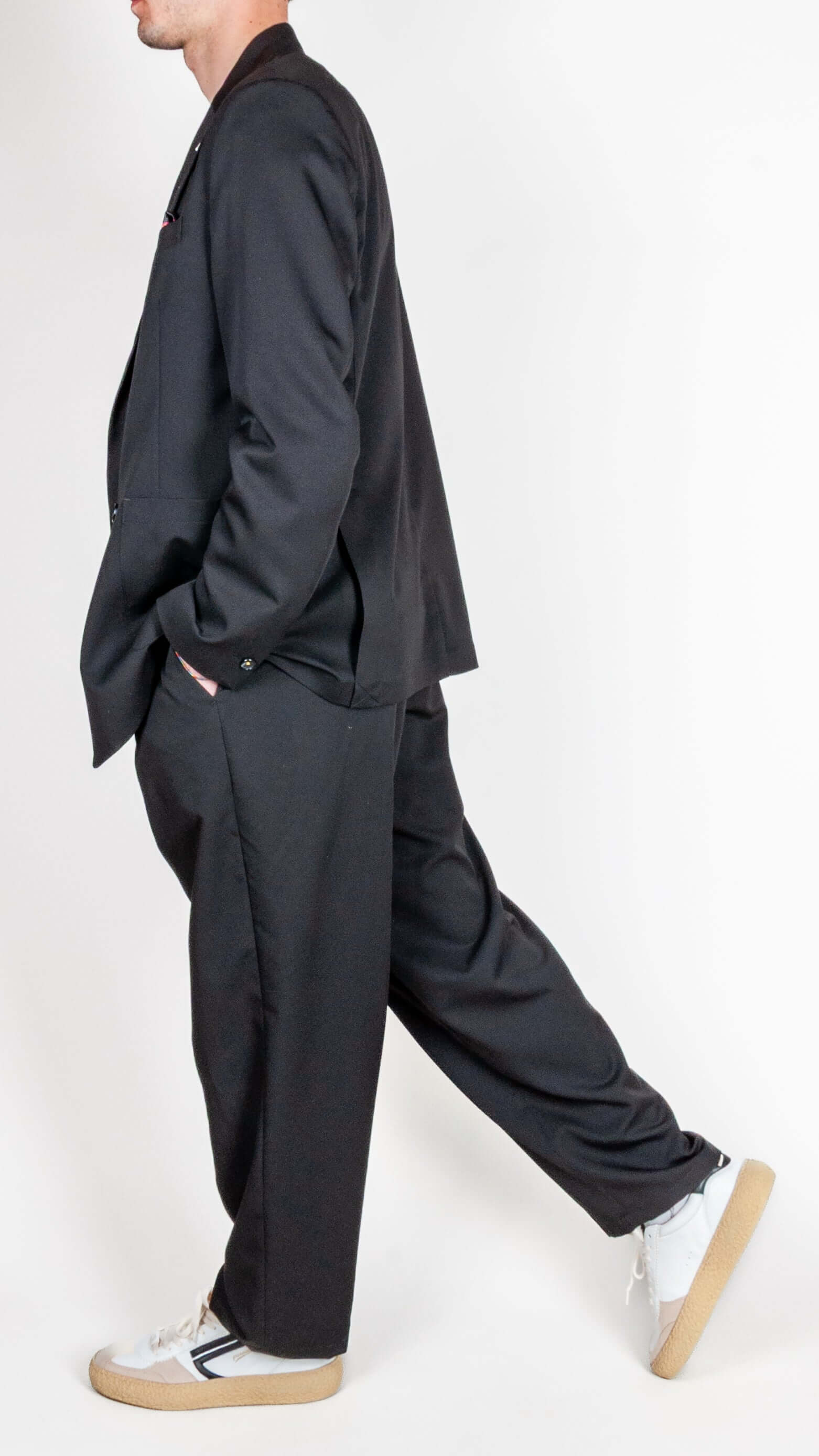 Abito doppiopetto Berna nero worn by a model in a stylish pose showcasing its sophisticated design.