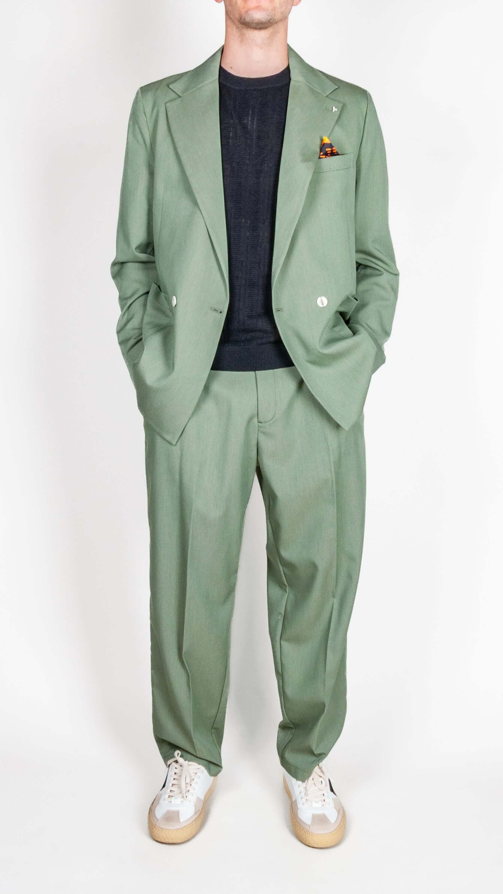 Abito doppiopetto Berna verde salvia worn with a black top and stylish sneakers, showcasing sophisticated style.