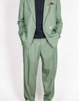Abito doppiopetto Berna verde salvia worn with a black top and stylish sneakers, showcasing sophisticated style.