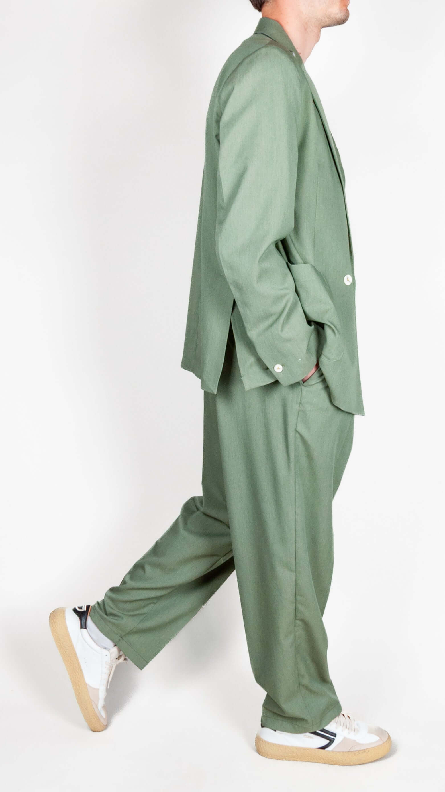 Abito doppiopetto Berna verde salvia worn by model in stylish pose.