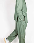 Abito doppiopetto Berna verde salvia worn by model in stylish pose.