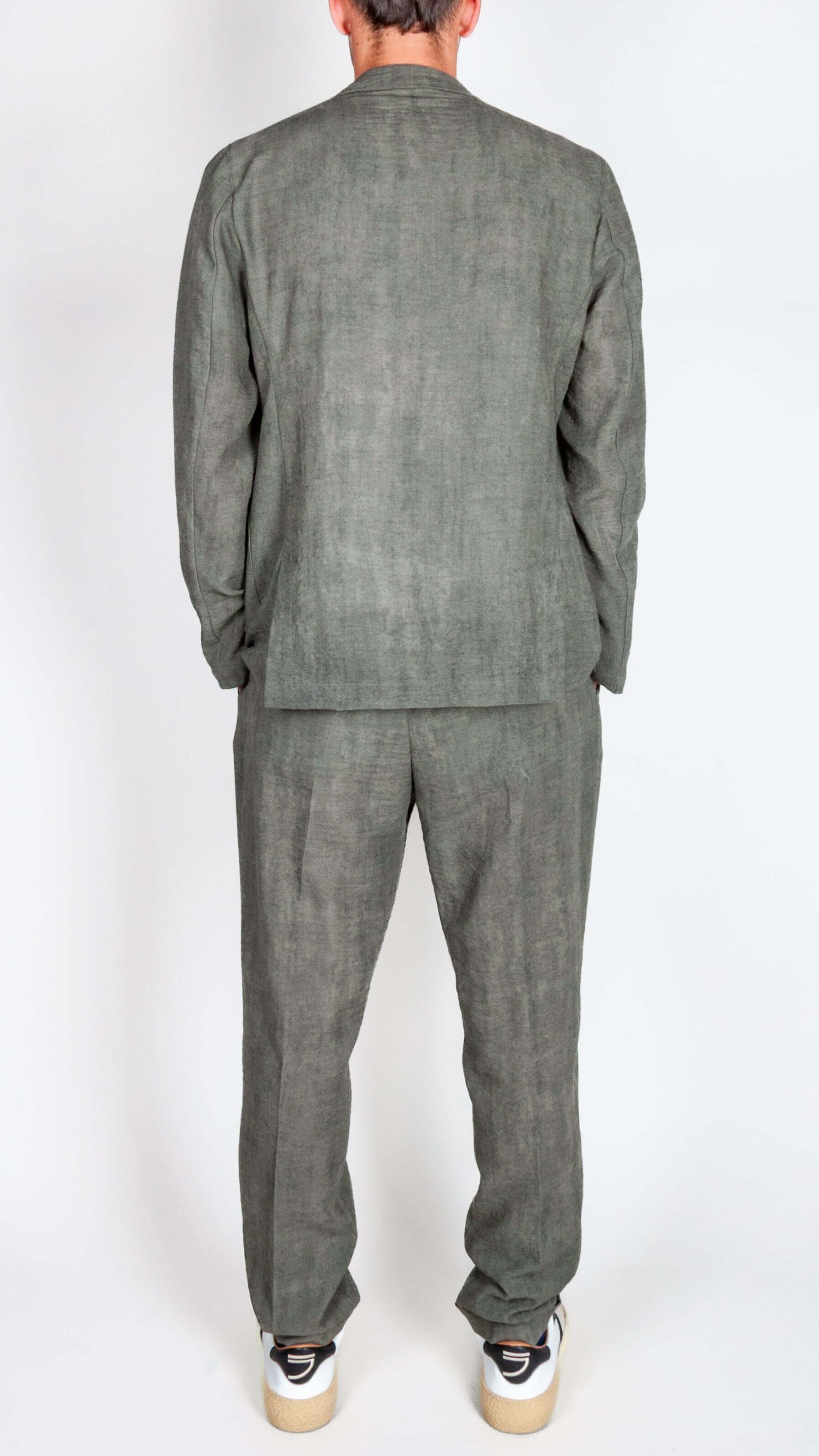 Back view of a man in a green military lightweight suit showcasing the abito leggero design.