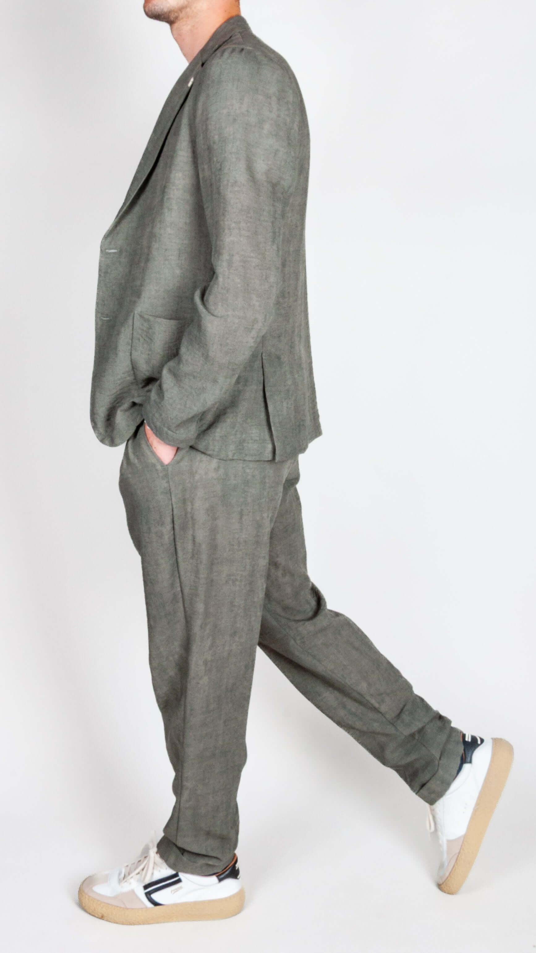 Modello in abito leggero Over D verde militare, indossato da uomo con scarpe bianche.