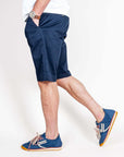 Bermuda cotone indossati da uomo in tessuto blu, modello Officina 36 con sneakers colorate.