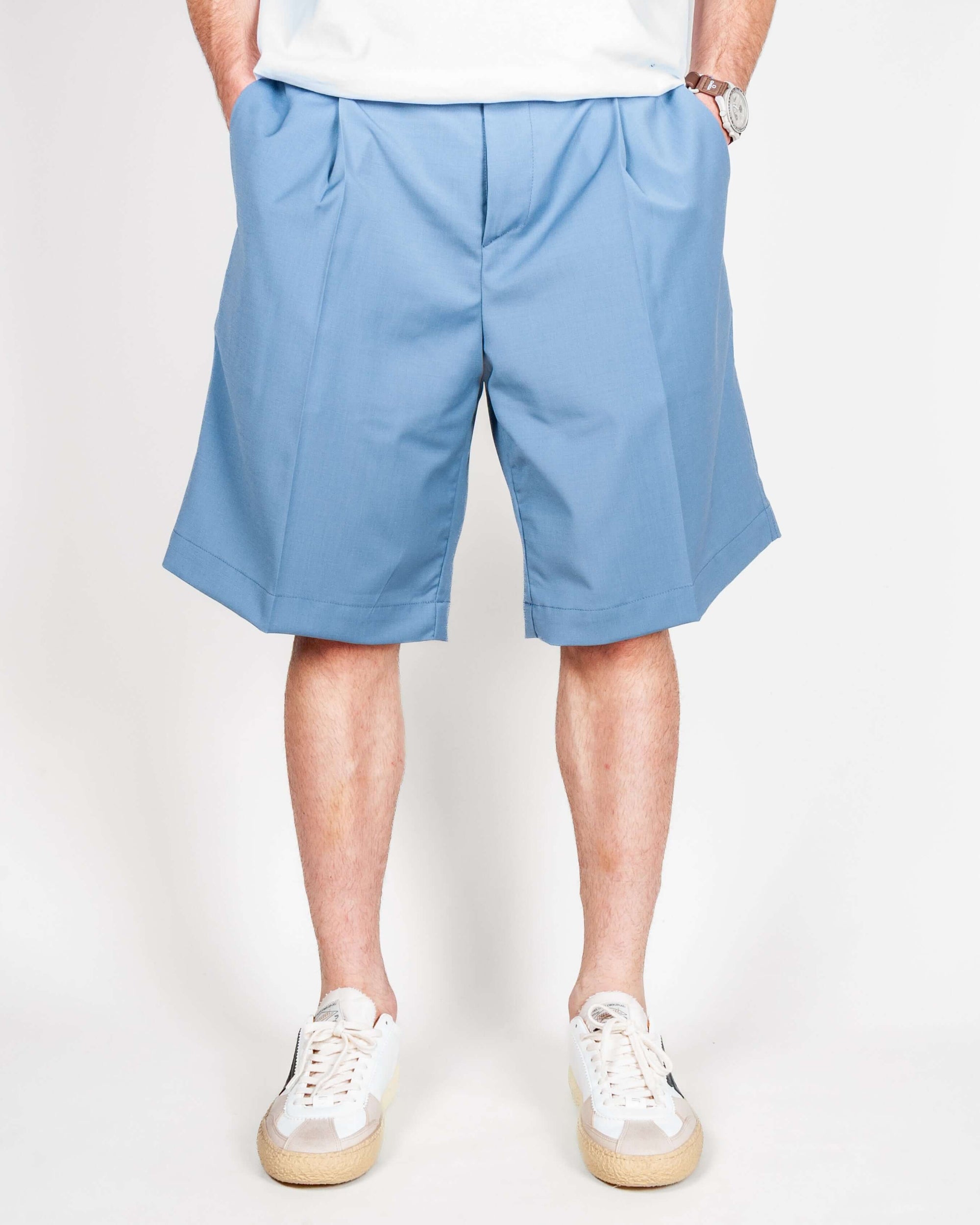 Bermuda Fresco in blue worn by a model showcasing a stylish summer outfit.